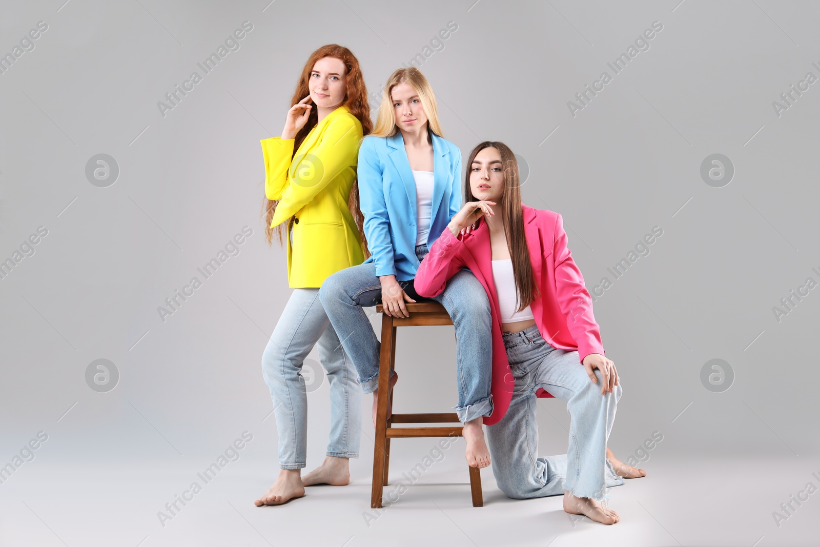 Beautiful women with different hair colors on light grey background Photo of Beautiful women with different hair colors on light grey background
