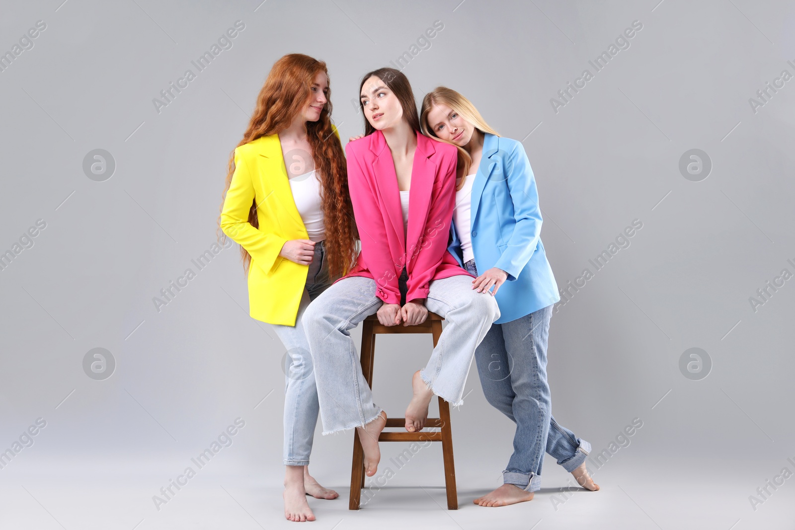 Beautiful women with different hair colors on light grey background Photo of Beautiful women with different hair colors on light grey background