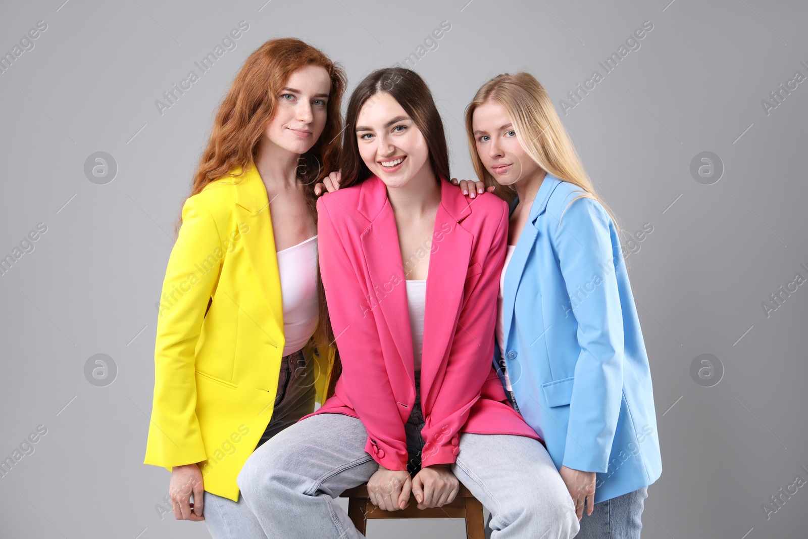 Beautiful women with different hair colors on light grey background Photo of Beautiful women with different hair colors on light grey background