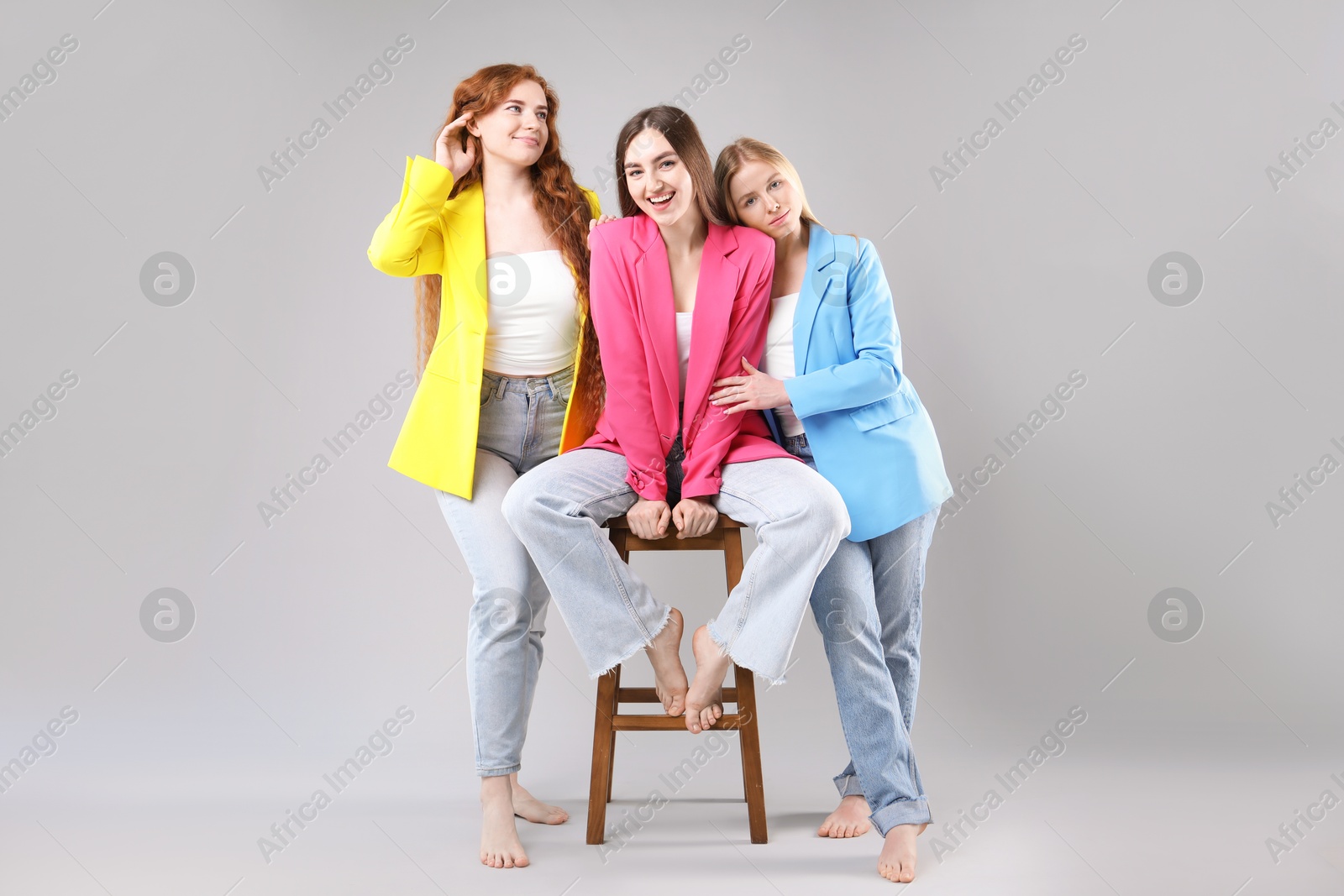 Beautiful women with different hair colors on light grey background Photo of Beautiful women with different hair colors on light grey background