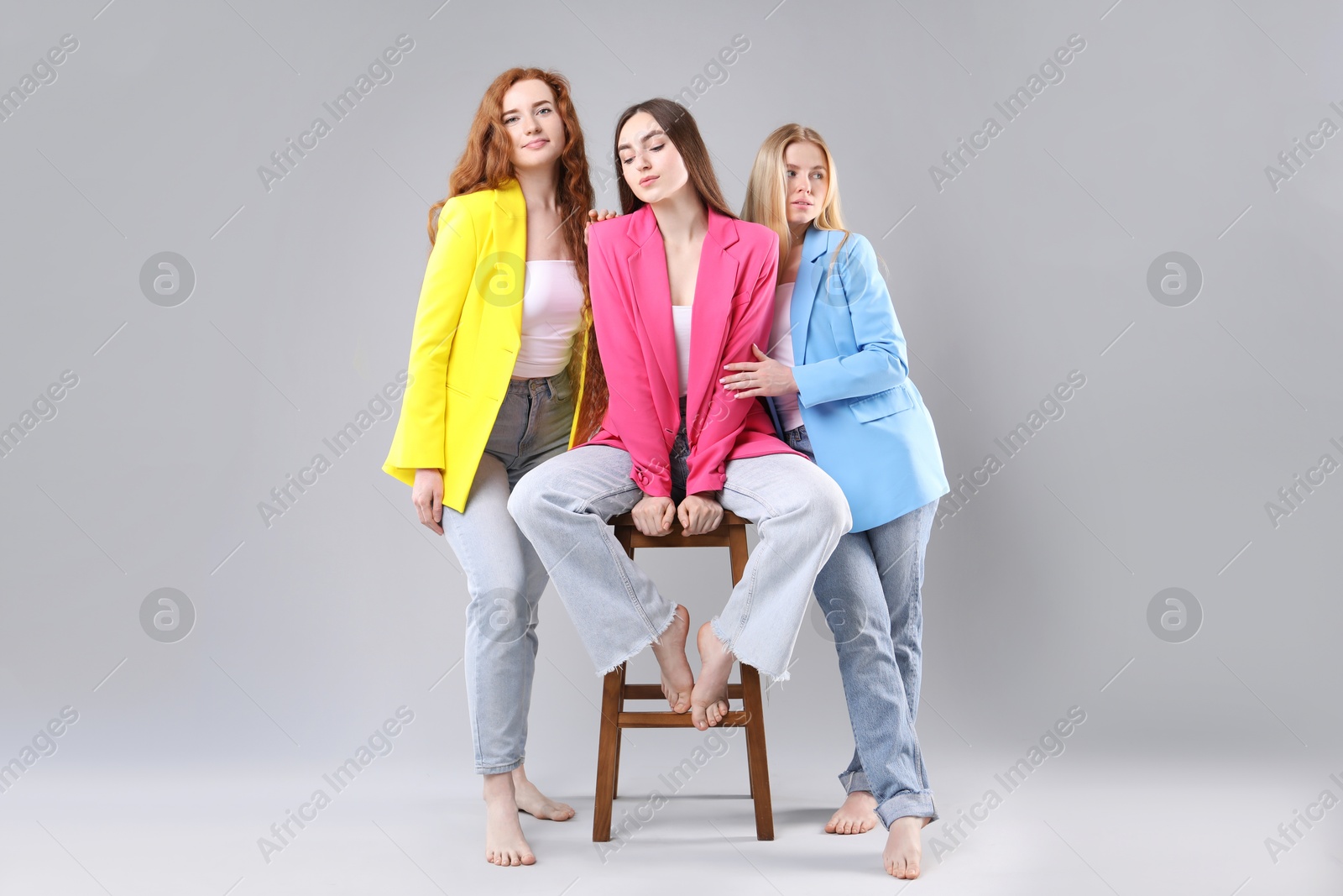 Beautiful women with different hair colors on light grey background Photo of Beautiful women with different hair colors on light grey background