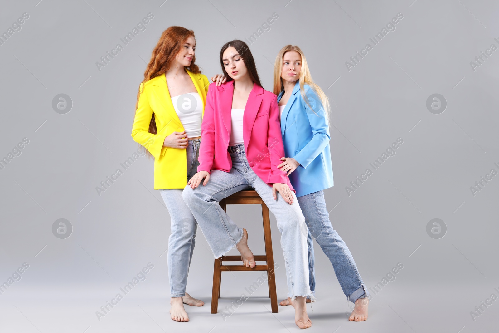 Beautiful women with different hair colors on light grey background Photo of Beautiful women with different hair colors on light grey background