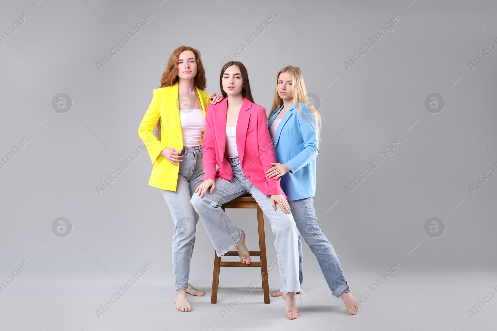 Beautiful women with different hair colors on light grey background Photo of Beautiful women with different hair colors on light grey background