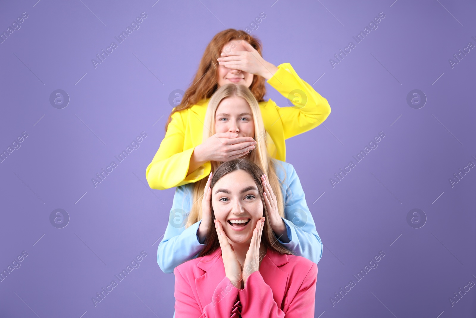 Beautiful women with different hair colors having fun on purple background Photo of Beautiful women with different hair colors having fun on purple background