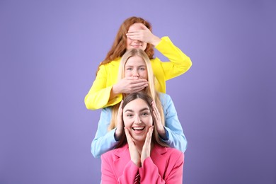 Photo of Beautiful women with different hair colors having fun on purple background