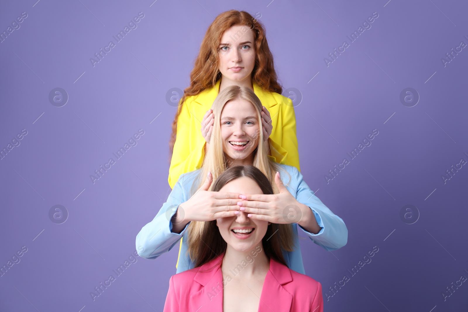 Beautiful women with different hair colors having fun on purple background Photo of Beautiful women with different hair colors having fun on purple background