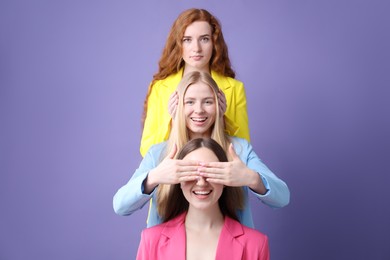 Photo of Beautiful women with different hair colors having fun on purple background