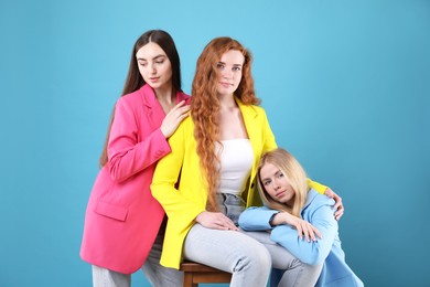 Photo of Beautiful women with different hair colors on light blue background