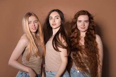 Photo of Beautiful women with different hair colors on dark beige background