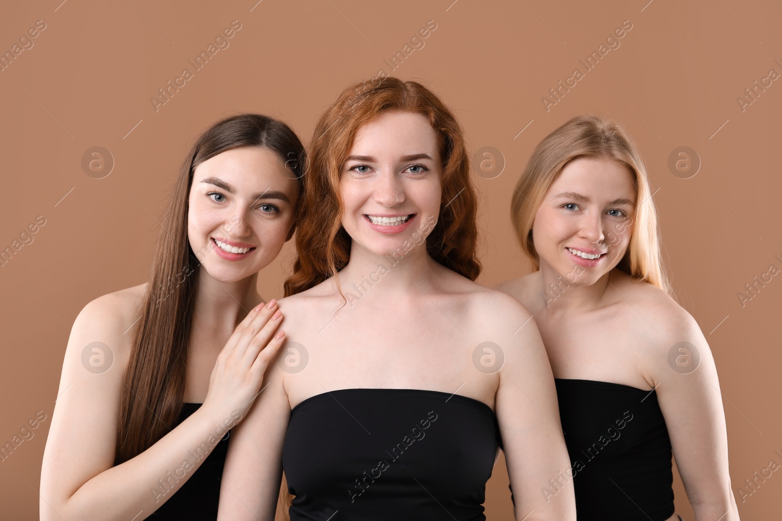 Photo of Beautiful women with different hair colors on dark beige background
