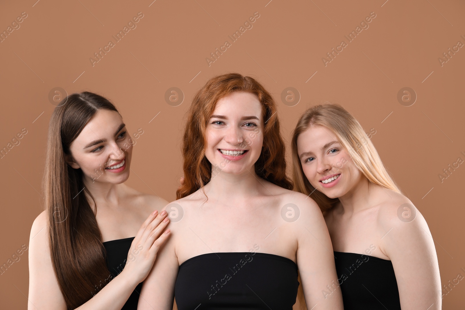 Beautiful women with different hair colors on dark beige background Photo of Beautiful women with different hair colors on dark beige background