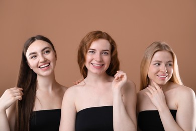 Photo of Beautiful women with different hair colors on dark beige background