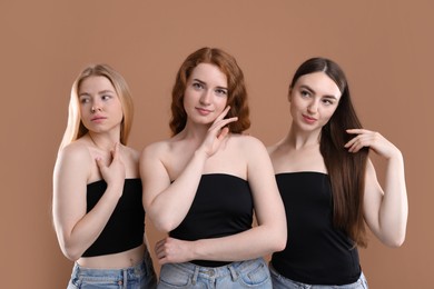 Photo of Beautiful women with different hair colors on dark beige background