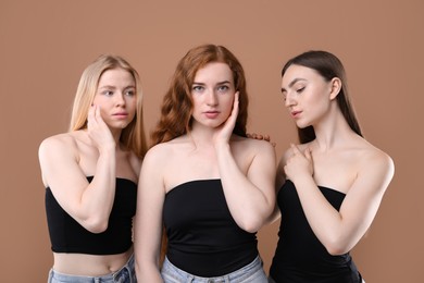 Photo of Beautiful women with different hair colors on dark beige background