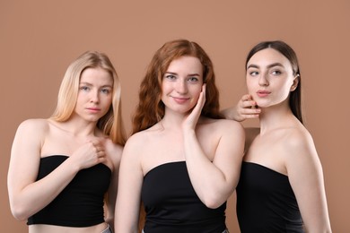 Photo of Beautiful women with different hair colors on dark beige background