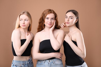 Photo of Beautiful women with different hair colors on dark beige background