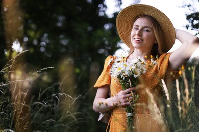 Photo of Beautiful woman with bouquet of wildflowers in meadow
