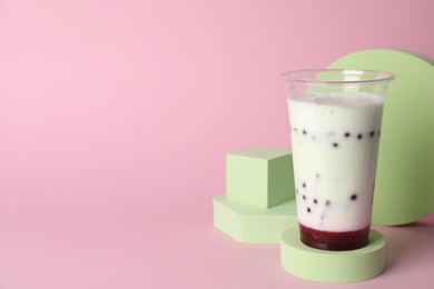 Photo of Tasty refreshing bubble tea on pink background. Space for text