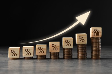 Image of Increase in real estate value. Coins, cubes with percent signs and house icon on table. Growing price represented by arrow