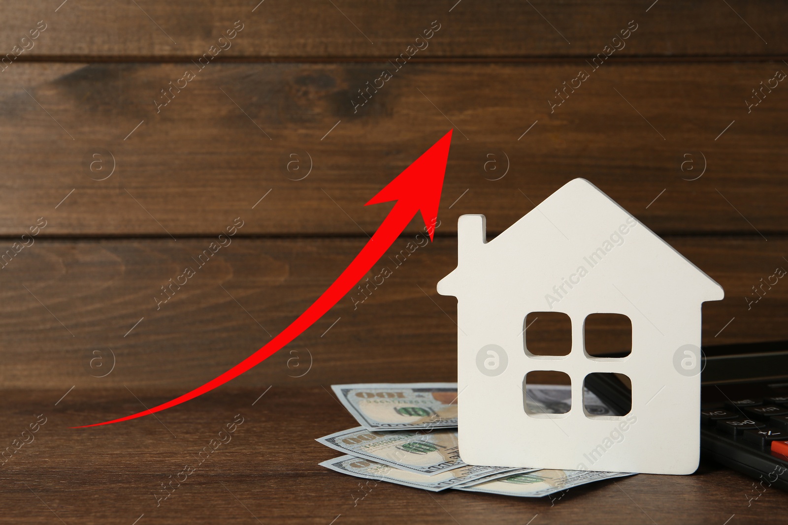 Increase in real estate value. House model and money on table. Growing price represented by arrow Image of Increase in real estate value. House model and money on table. Growing price represented by arrow