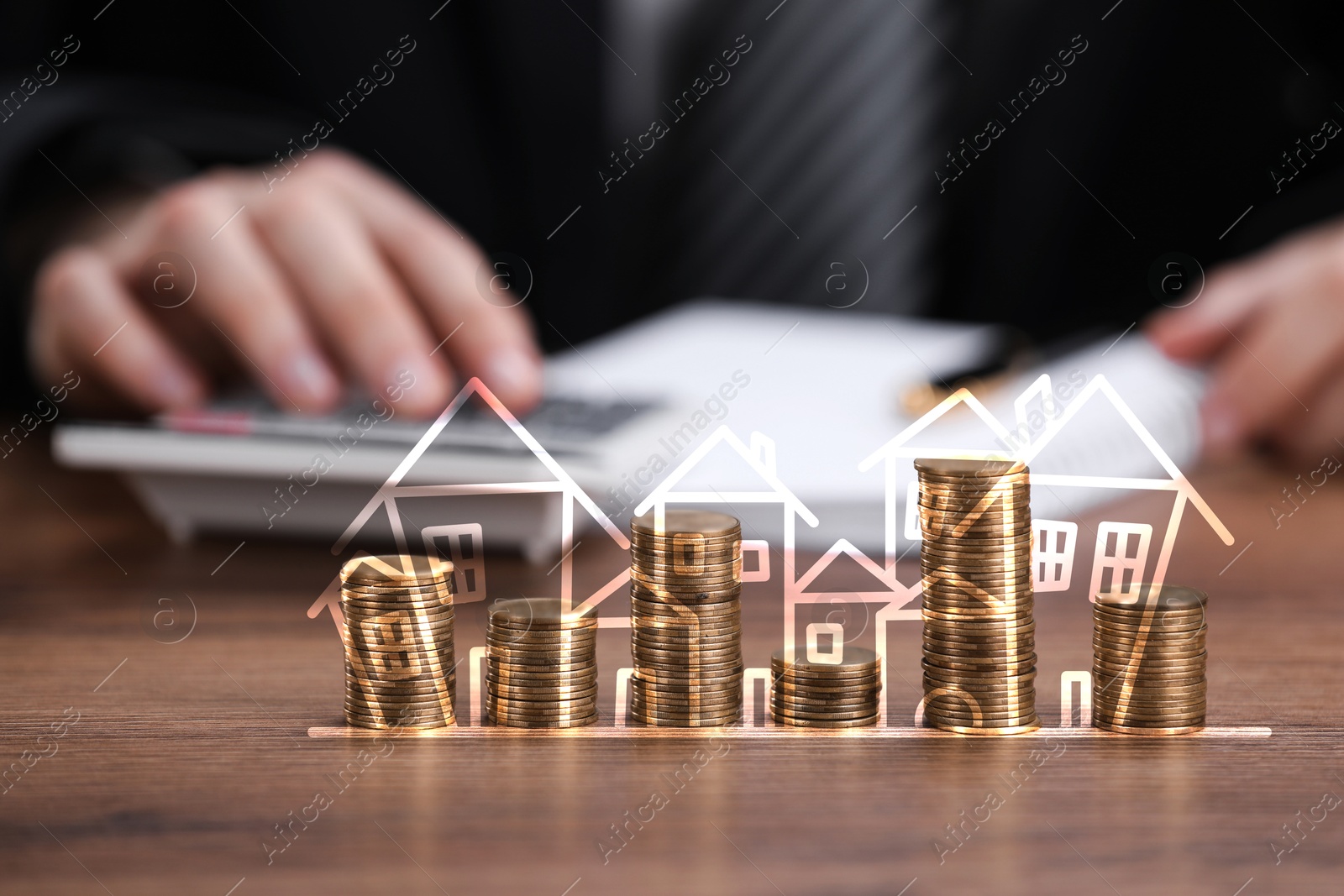 Increase in real estate value. Stacked coins with illustration of houses. Man working at table, selective focus Image of Increase in real estate value. Stacked coins with illustration of houses. Man working at table, selective focus