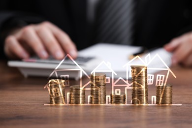Image of Increase in real estate value. Stacked coins with illustration of houses. Man working at table, selective focus