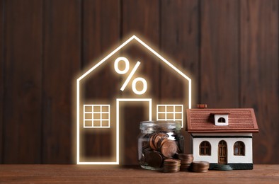 Image of Increase in real estate value. Coins and illustration of house with percent sign against wooden background