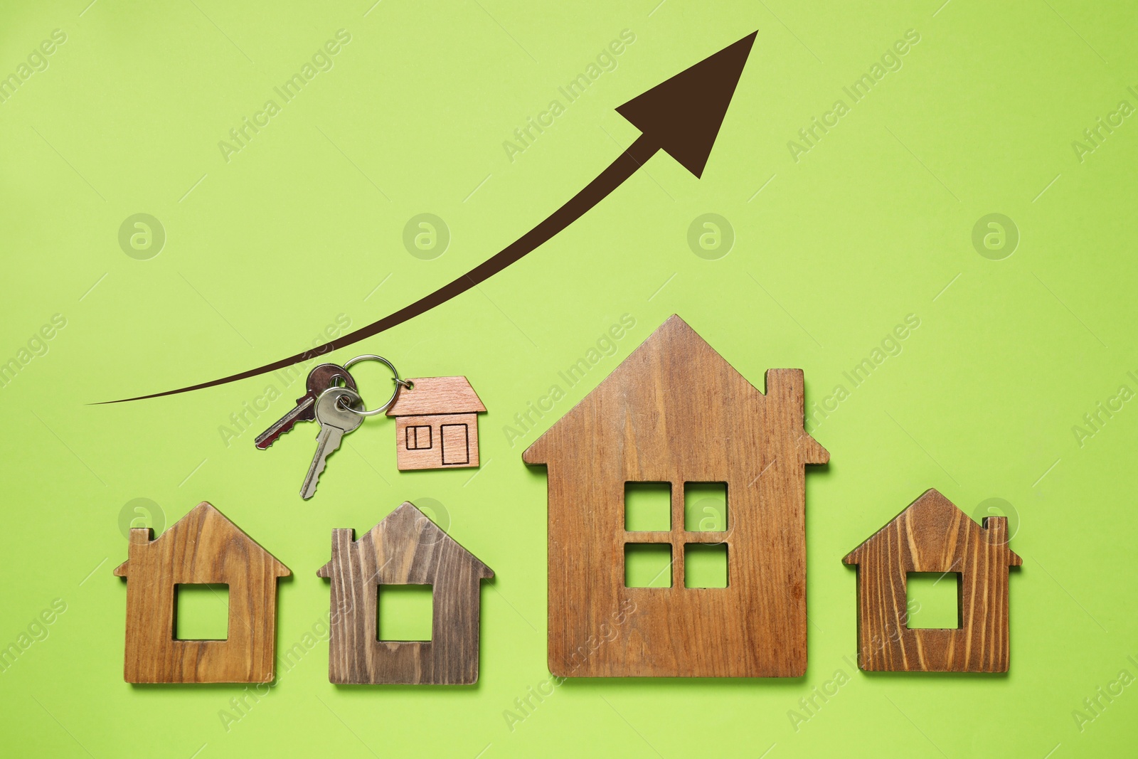Image of Increase in real estate value. House models and key on light green background, top view. Growing price represented by arrow