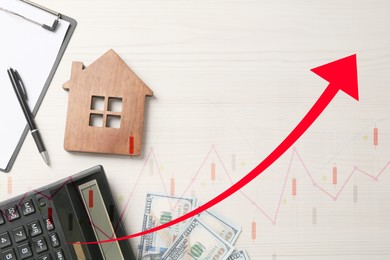 Image of Increase in real estate value. House model, money and calculator on table, top view. Growing price represented by graph and arrow