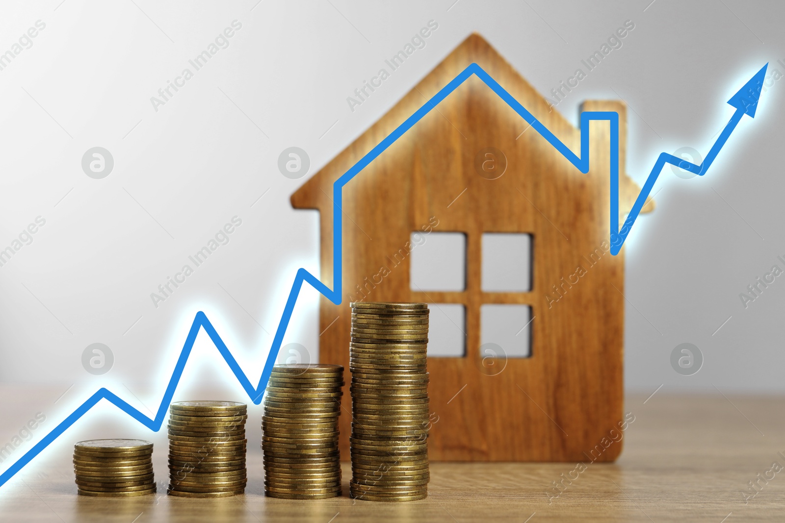 Increase in real estate value. House model and coins on table. Growing price represented by arrow Image of Increase in real estate value. House model and coins on table. Growing price represented by arrow
