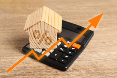 Image of Increase in real estate value. House model with percent sign and calculator on table. Growing price represented by arrow