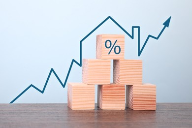Image of Increase in real estate value. Arrow with house shape above wooden cubes on table