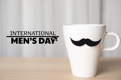 Image of International Men's Day card with hat illustration. Cup with paper moustache on table