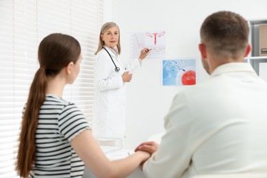 Photo of In vitro fertilization (IVF). Couple having consultation with doctor in reproductive clinic, selective focus