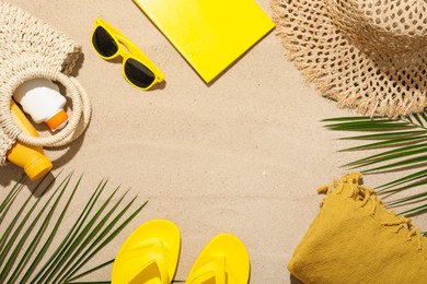 Photo of Flat lay composition with different beach accessories and palm leaves on sand outdoors, space for text