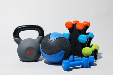 Photo of Medicine ball, kettlebell and dumbbells on light grey background