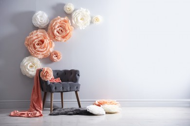 Photo of Photo zone with stylish floral decor and armchair in studio, space for text