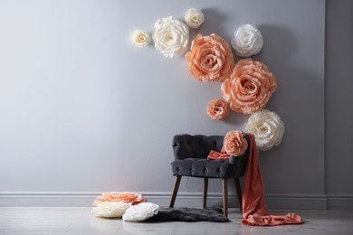 Photo of Photo zone with stylish floral decor and armchair in studio, space for text