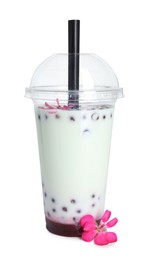Photo of Tasty refreshing bubble tea and flower isolated on white