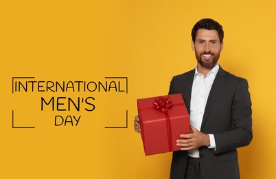Image of International Men's Day card. Happy man with gift box on orange background