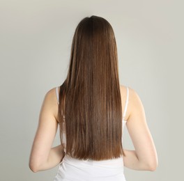 Image of Woman with perfect long hair on grey background, back view