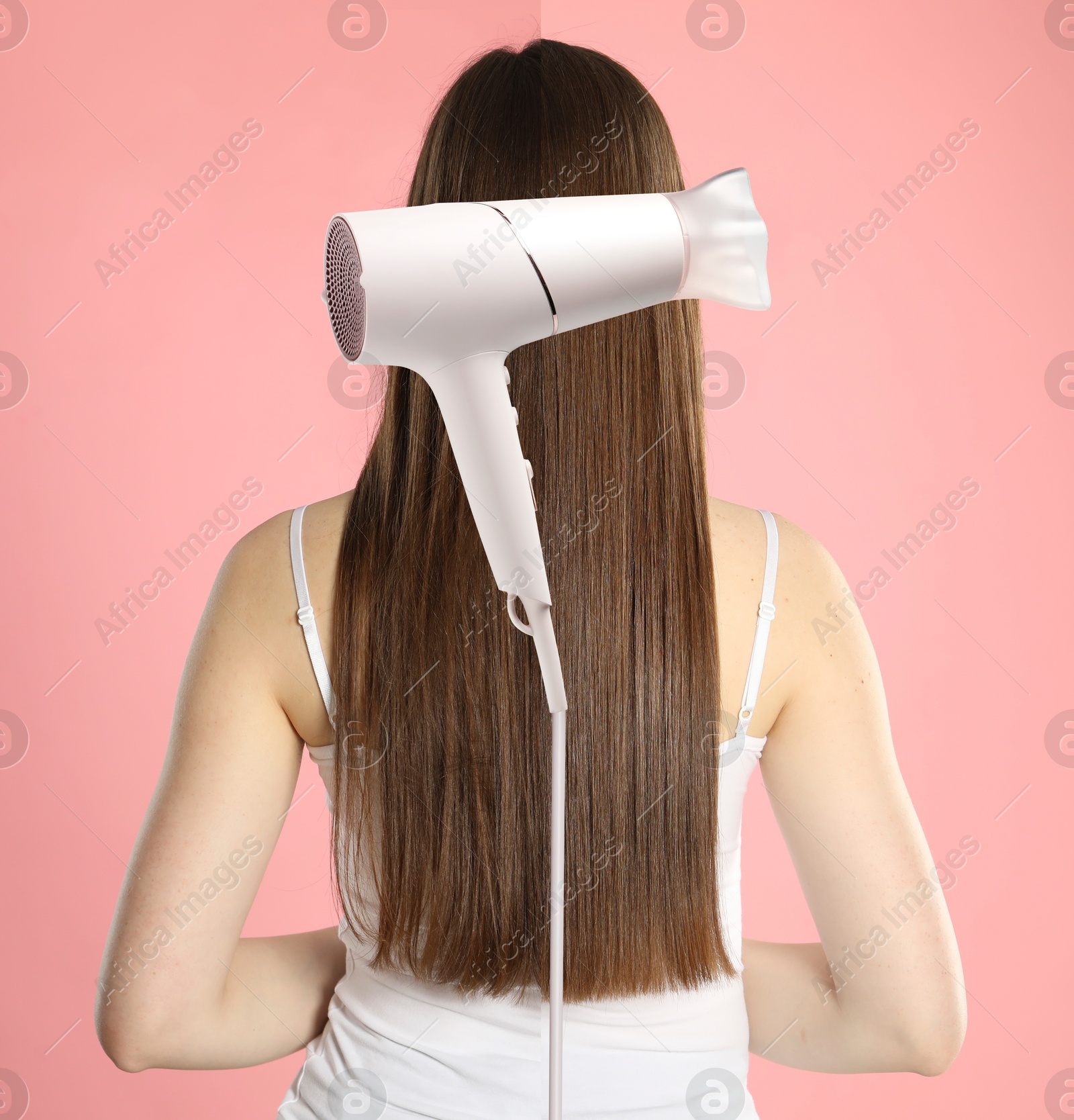 Photo of woman divided by hair dryer showing before and after hair styling, pink background Image of Photo of woman divided by hair dryer showing before and after hair styling, pink background