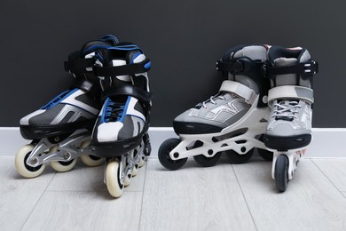 Photo of Pairs of roller skates on floor near black wall