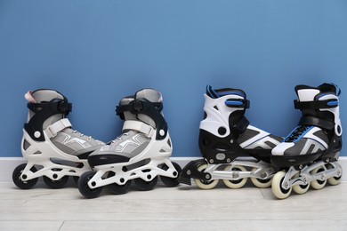 Photo of Pairs of roller skates on floor near light blue wall