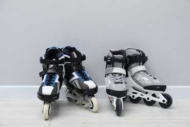 Photo of Pairs of roller skates on floor near white wall