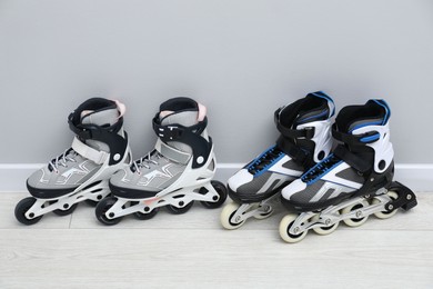 Photo of Pairs of roller skates on floor near white wall