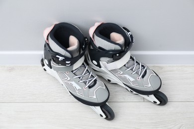 Photo of Pair of roller skates on floor near white wall