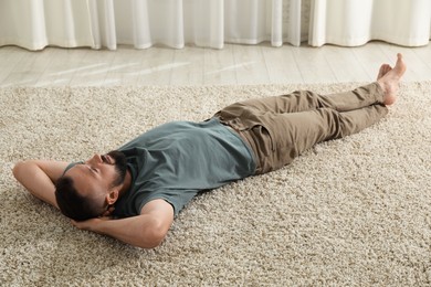 Photo of Harmony. Man lying on rug at home