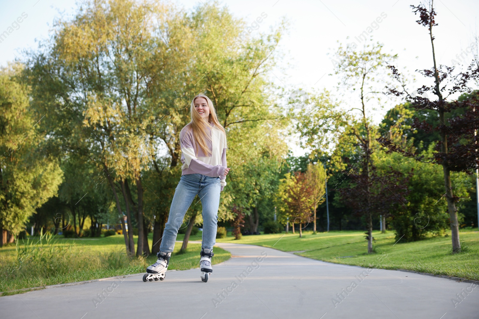 Happy young woman roller skating in park Photo of Happy young woman roller skating in park