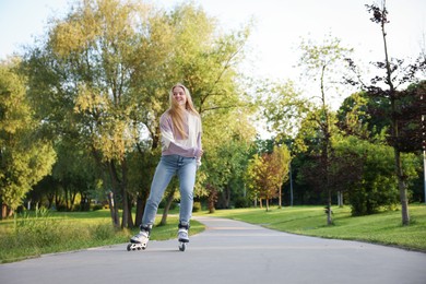 Photo of Happy young woman roller skating in park